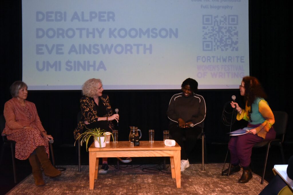 Four women seated on stage with microphones