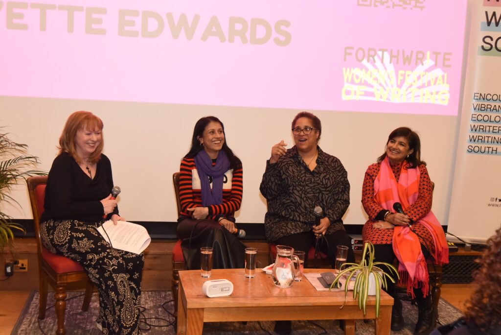 Four women on stage with microphones